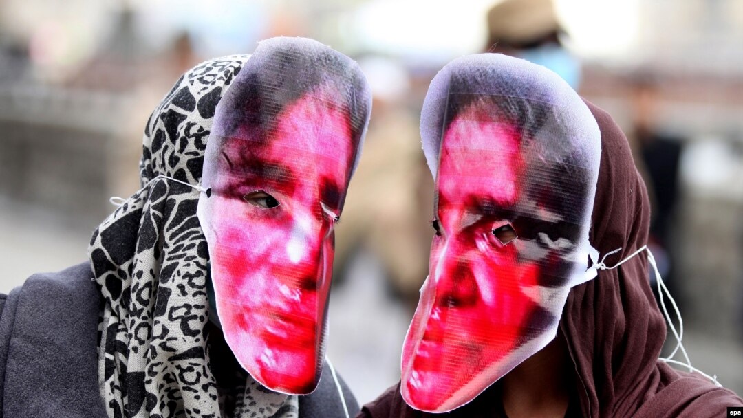 Afghan women in Kabul in March 2016 wear masks depicting Farkhunda Malikzada, who was killed by a mob a year earlier.