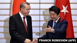 اردوغان می‌گوید نخست‌وزیر ژاپن «از من پرسید آیا می‌توانیم به‌طور مشترک در این زمینه اقدام کنیم. من گفتم: چراکه نه». در تصویر آبه و اردوغان در جریان دیداری در سال ۲۰۱۵ در توکیو.